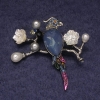 Broche-colgante «Loro» con cristal azul, strass de colores y cuentas, metal plateado 50×48 mm